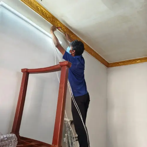 Technician installing a home CCTV camera along the ceiling in a Kolkata flat
